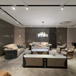 Cream Curved Leather Sofa with Dark Green Fan-Stitched Panels and Laced Edge Details